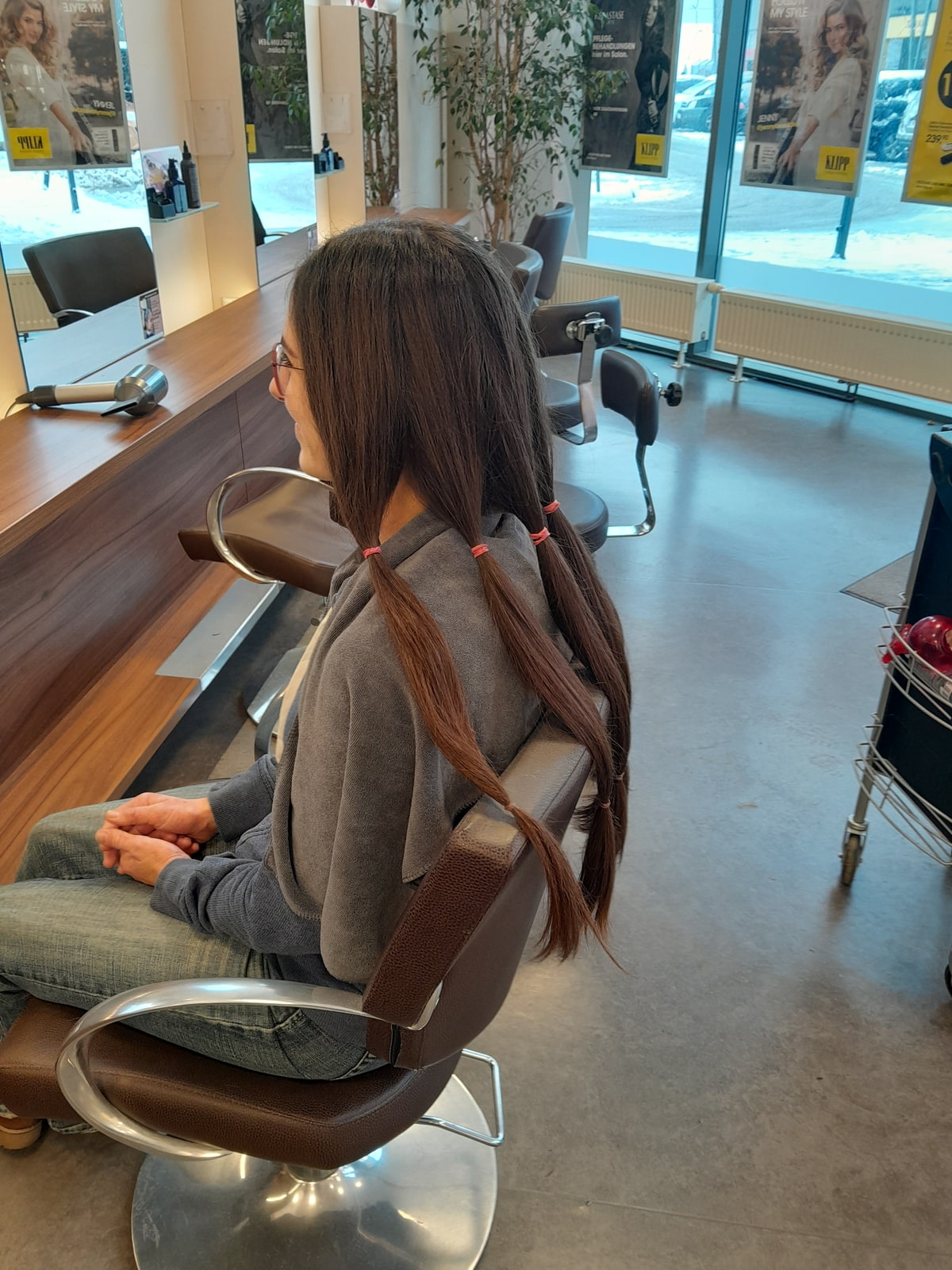 Eine Kundin bei KLIPP, deren Haare zusammengebunden werden
