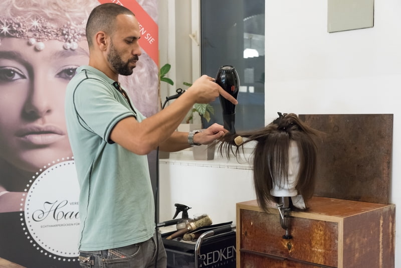 Ein Friseur stylt Perücke