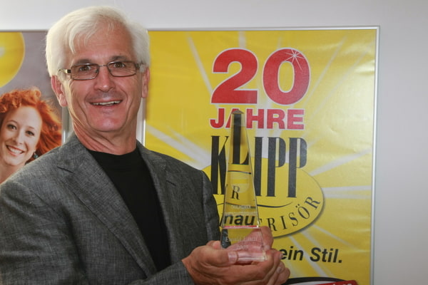 Mann steht vor einem KLIPP Plakat