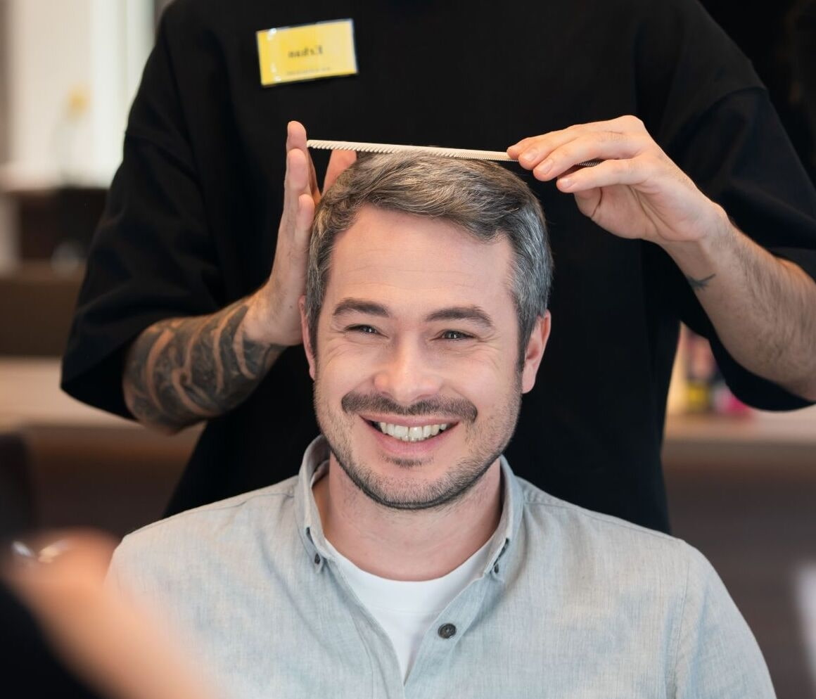 Friseur frisiert Mann