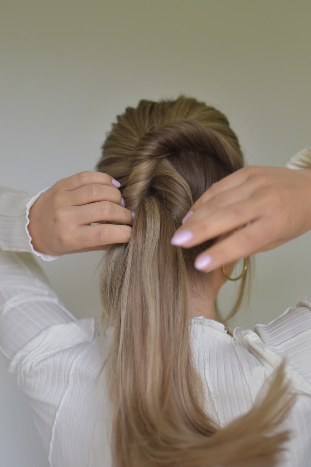 Frau von hinten bindet sich Haare
