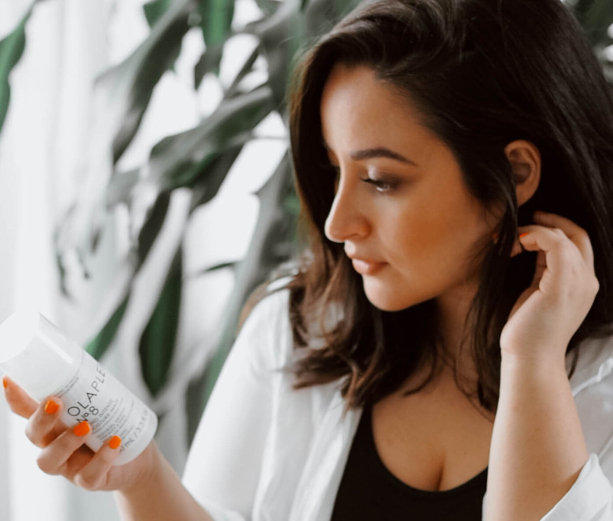 Frau sieht sich eine Flasche eines Olaplex-Produktes an