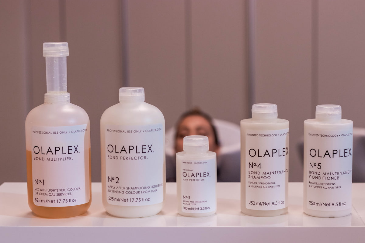 Farbbehandlung mit Olaplex Fünf Olaplex-Produkte nebeneinander aufgereiht