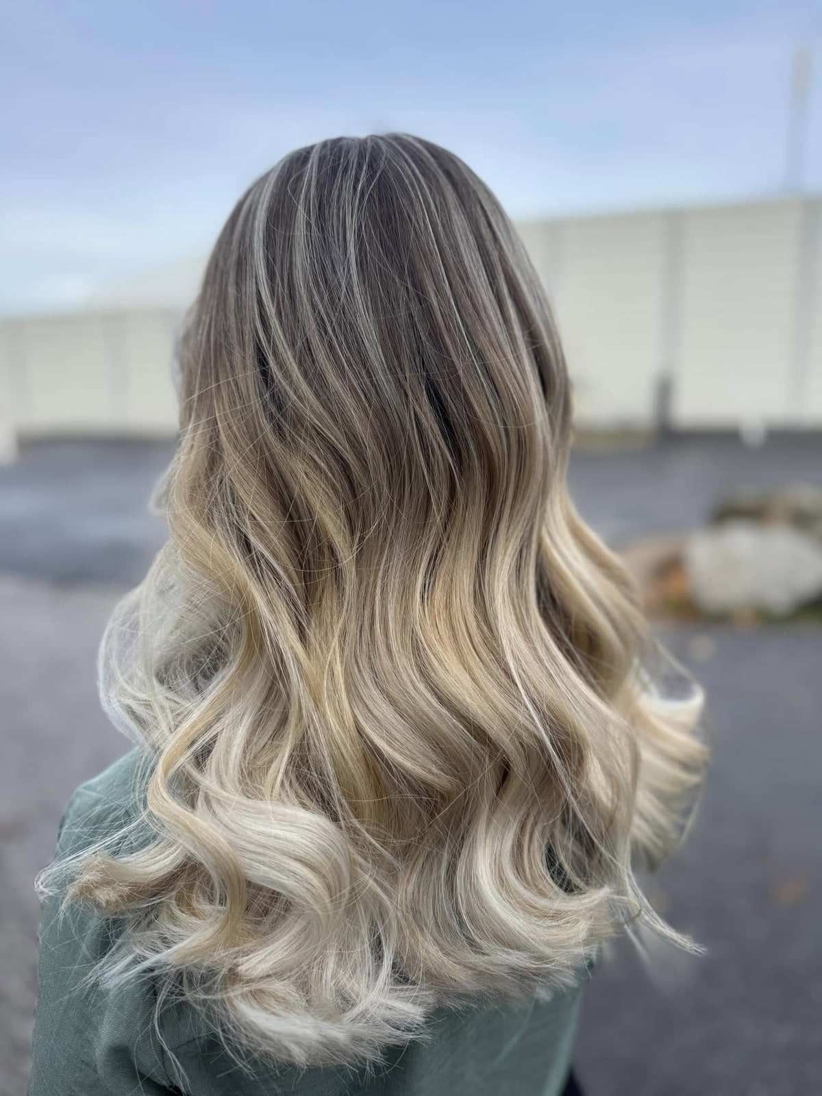 Langanhaltende Farbintensität Frau mit blond gefärbten Strähnen zeigt ihr Haar von hinten