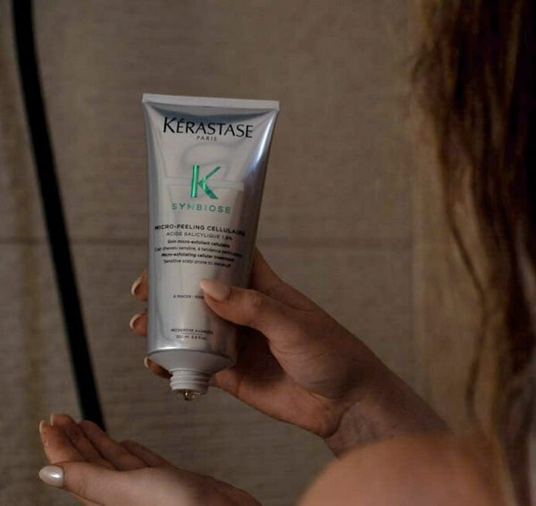 Conditioner als Haarpflege Frau benutzt Conditioner von Kerastase unter der Dusche