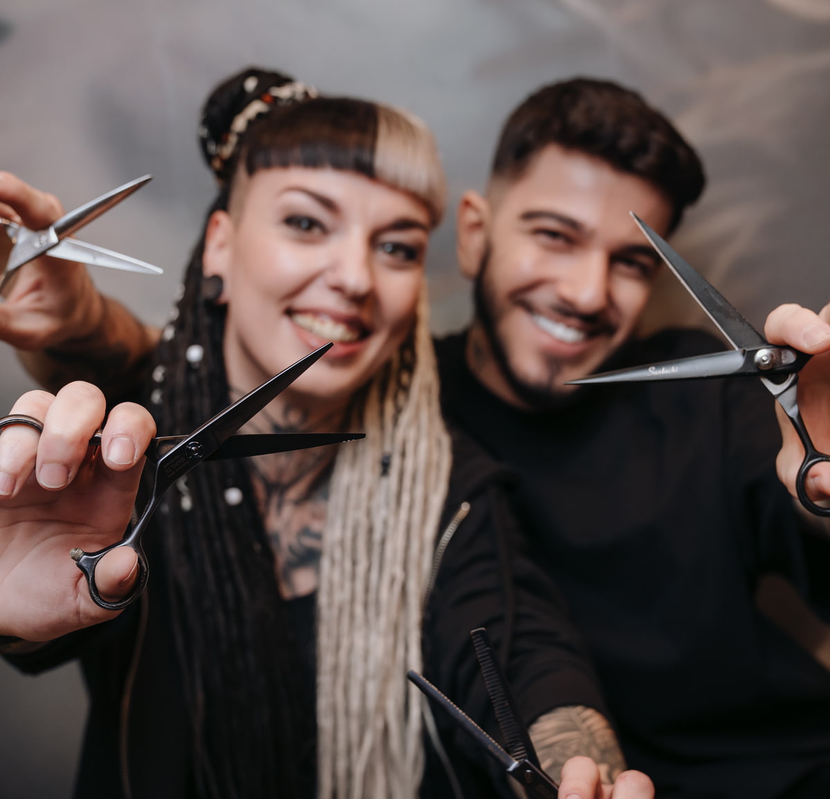 Ein Mann und eine Frau halten jeweils eine Schere in der Hand