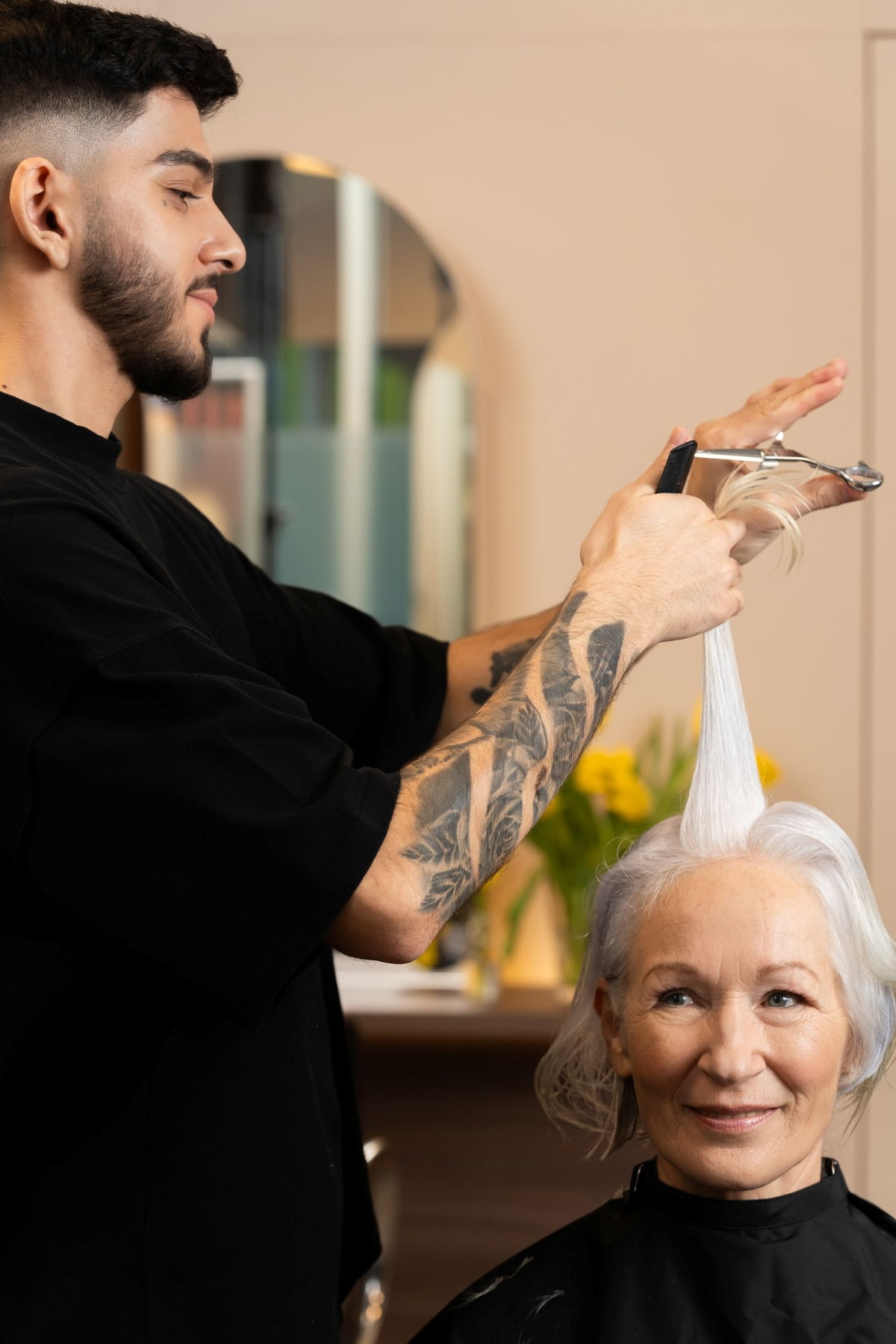 Mann schneidet älterer Dame die Haare 