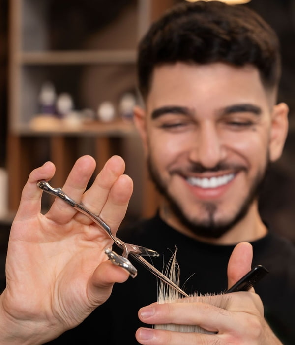 Friseur schneidet die Haarspitzen mit einer Schere