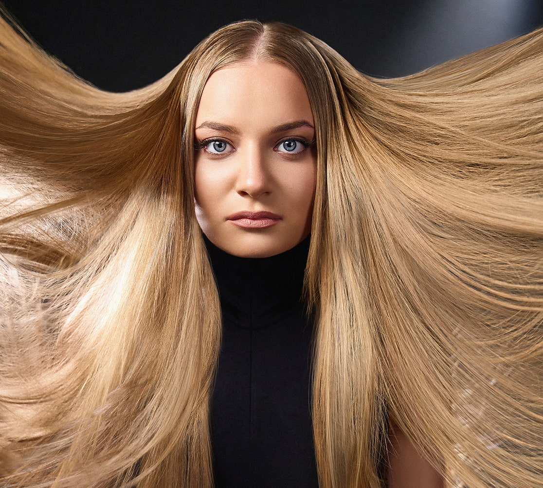 Eine Frau mit blondem, glatten Haar blickt in die Kamera