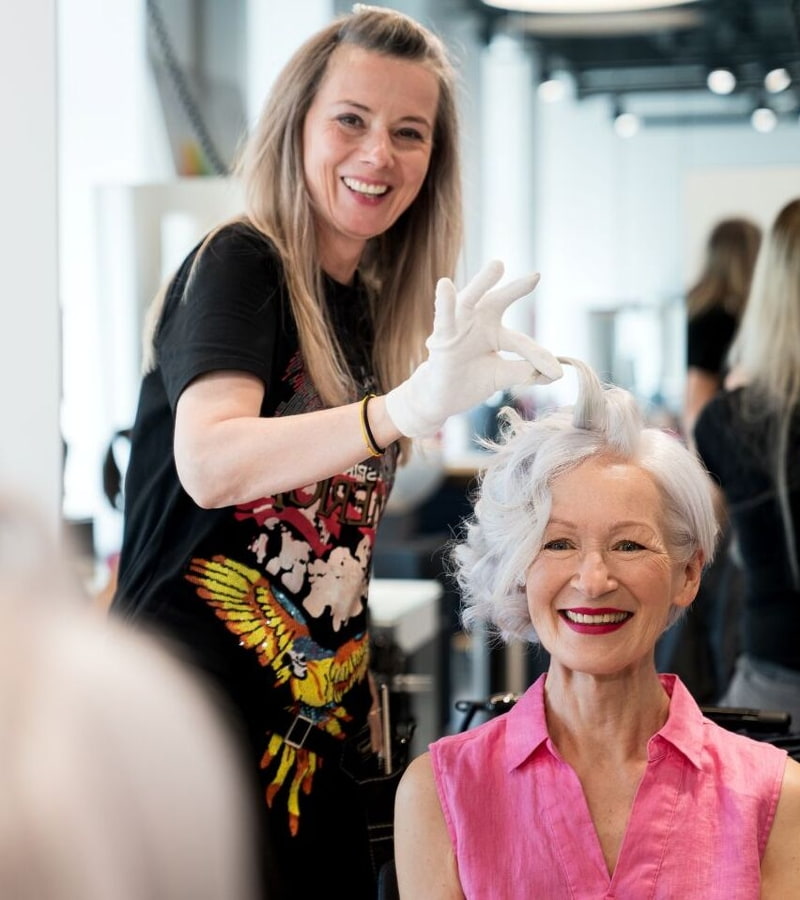 Friseurin stylt blonde Frau 