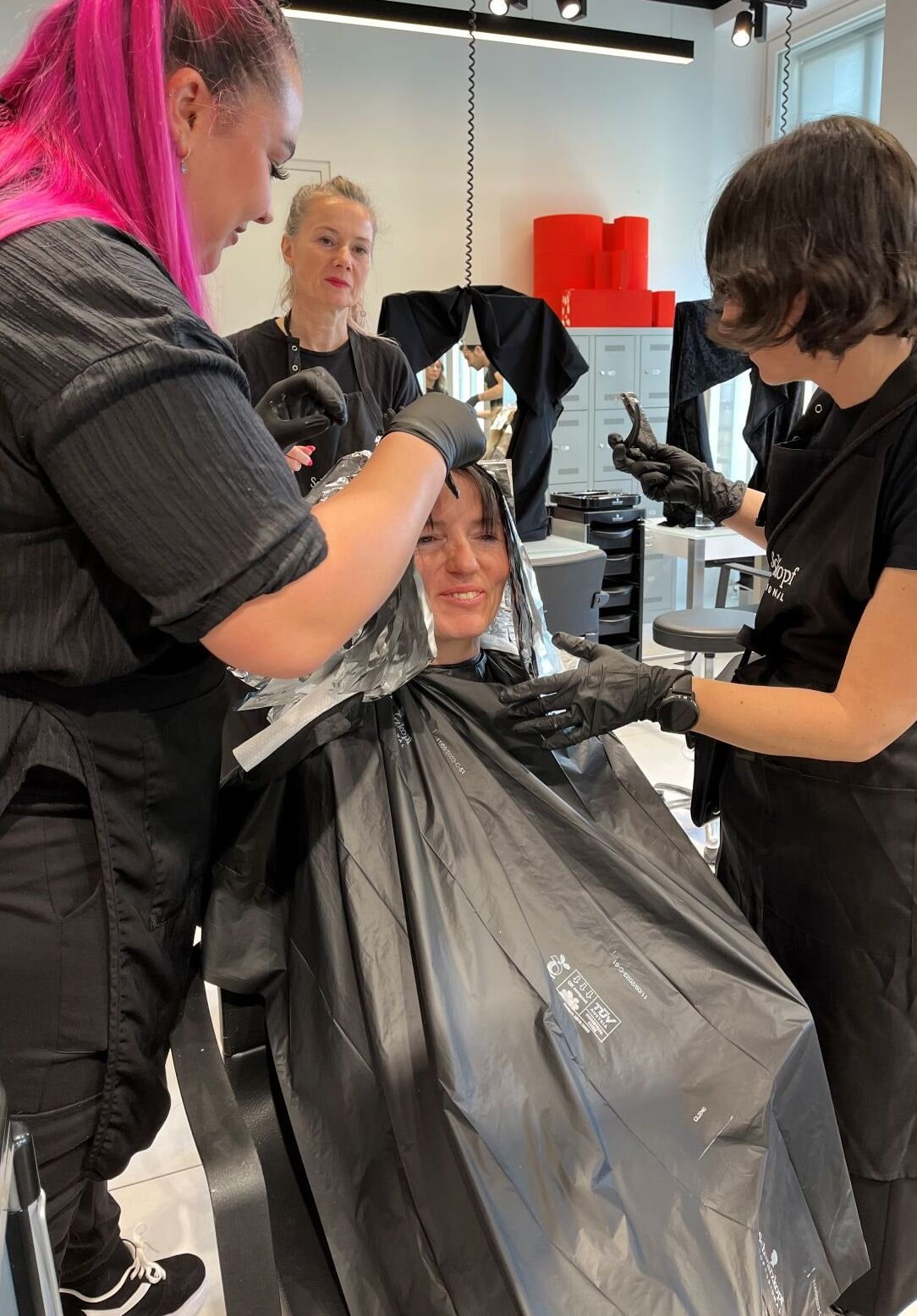 Friseurin färbt Kundin die Haare