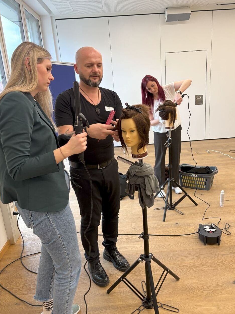Friseure bekommen Schulung an Puppenköpfen